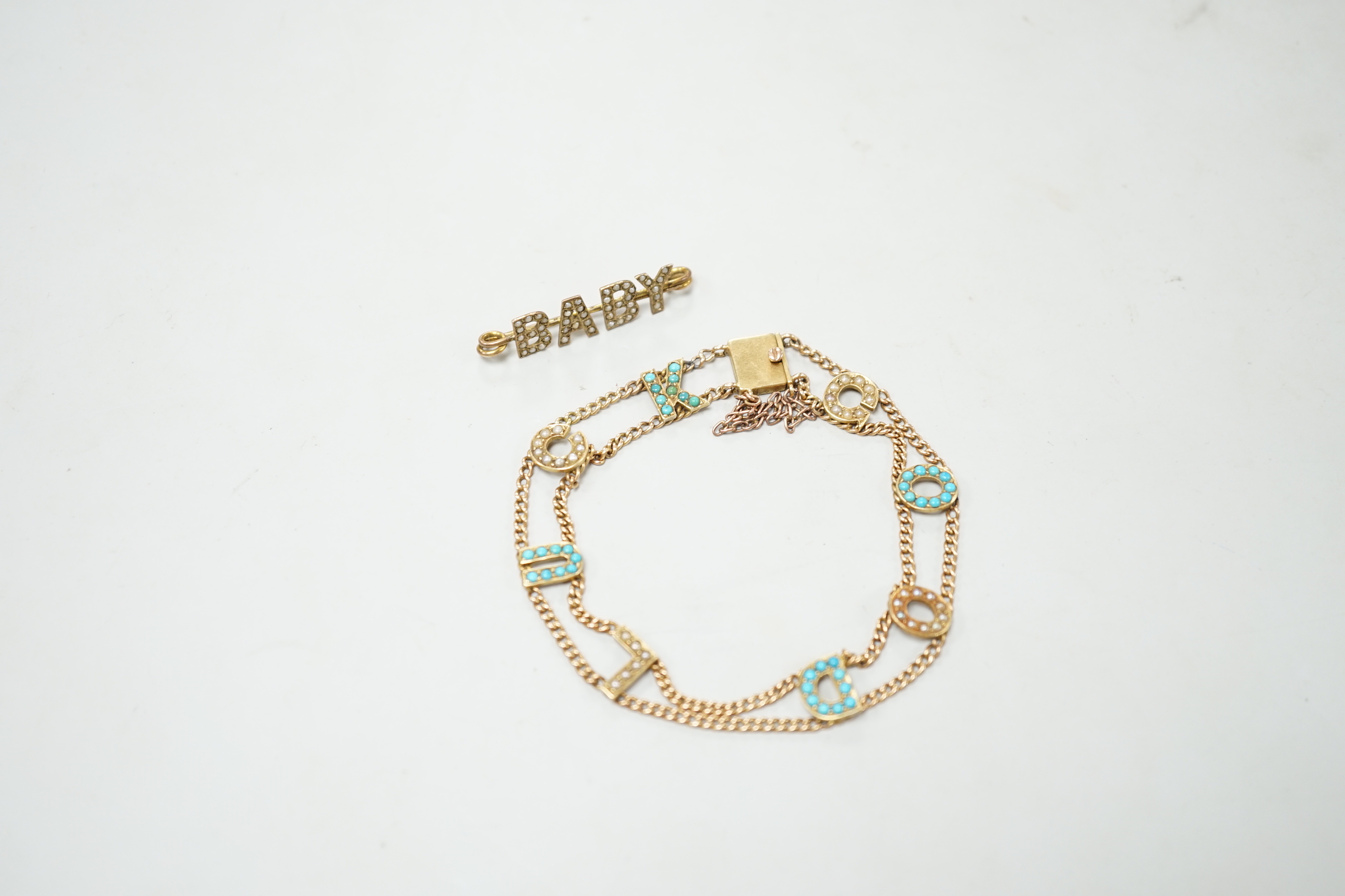 An Edwardian 15ct?, turquoise and seed pearl set 'Good Luck' chain bracelet, 17cm and a yellow metal and seed pearl set 'Baby' bar brooch.